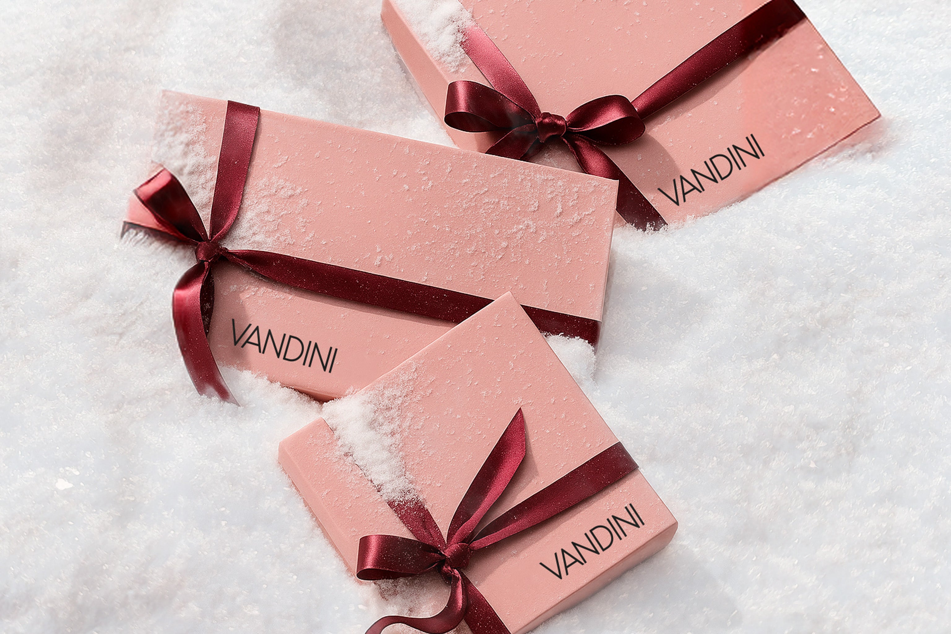 3 rosa VANDINI Geschenkboxen mit Schleifen im Schnee