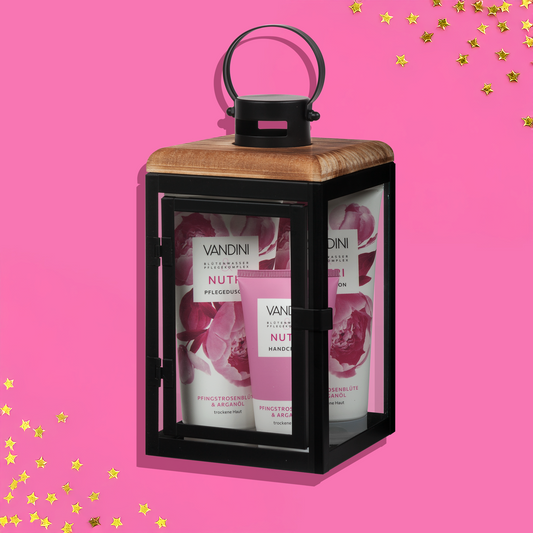 NUTRI Pflegeprodukte in schwarzer Laterne aus Metall und Glas vor rosa Hintergrund als Weihnachtsgeschenkset